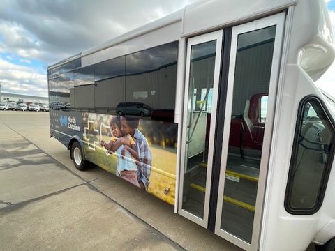 Outreach bus passenger side with glass entry doors