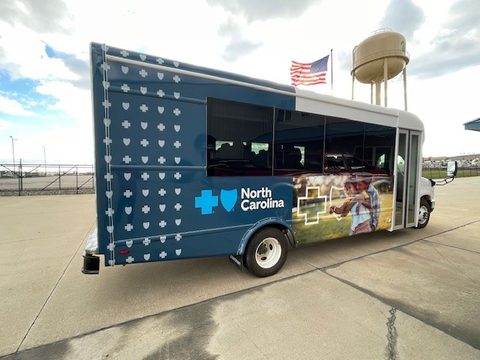 Outreach bus, rear three-quarter, with the Wakarusa water tower behind