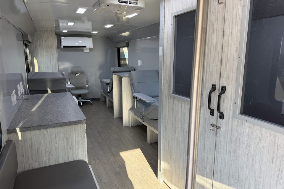 Bloodmobile interior looking aft: donor chairs, screening booth doors, cabinetry