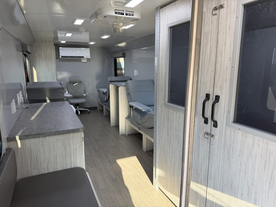 Bloodmobile interior looking aft: donor chairs, screening booth doors, cabinetry