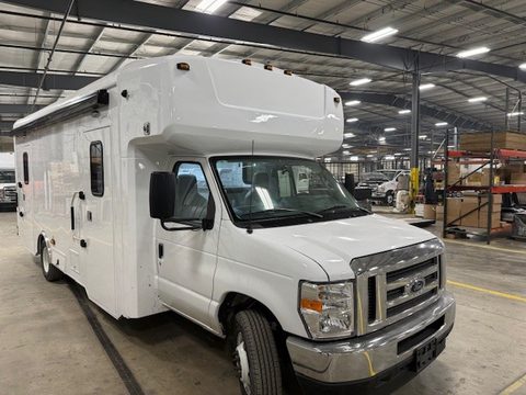 White bookmobile on a Ford E-450 cutaway, front three-quarter, in the HLE plant
