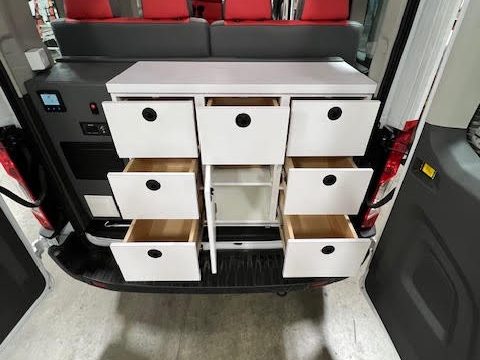 Rear doors open: white storage drawers and cabinets