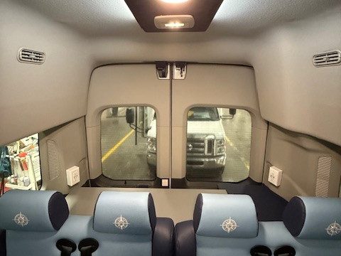 Blue upholstered forward-facing seats at the rear of the van