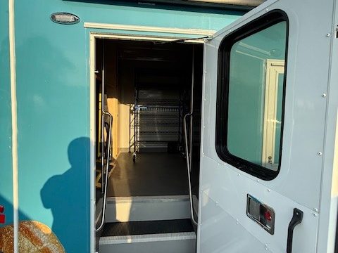 Curbside entry door open with steps on the food pantry