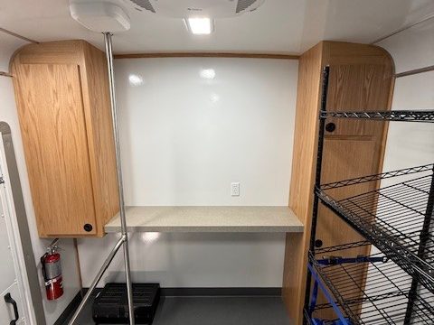 Counter with oak cabinets at the front of the food pantry