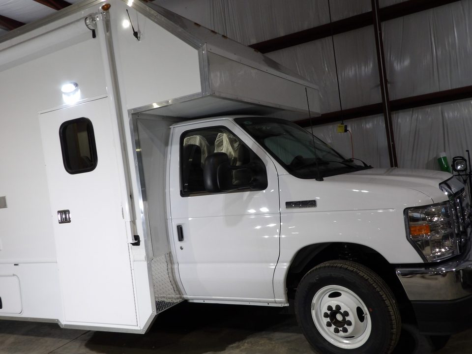 Mobile office on a Ford E-450 cutaway, white, front three-quarter, in the plant