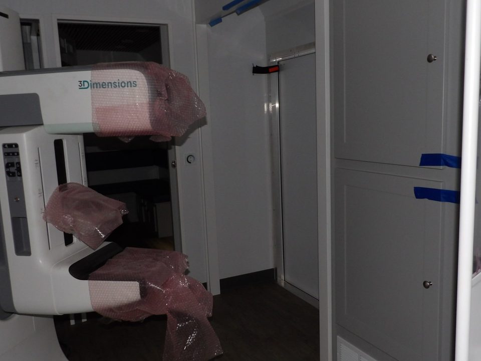 Mammography system in protective wrap inside the exam room