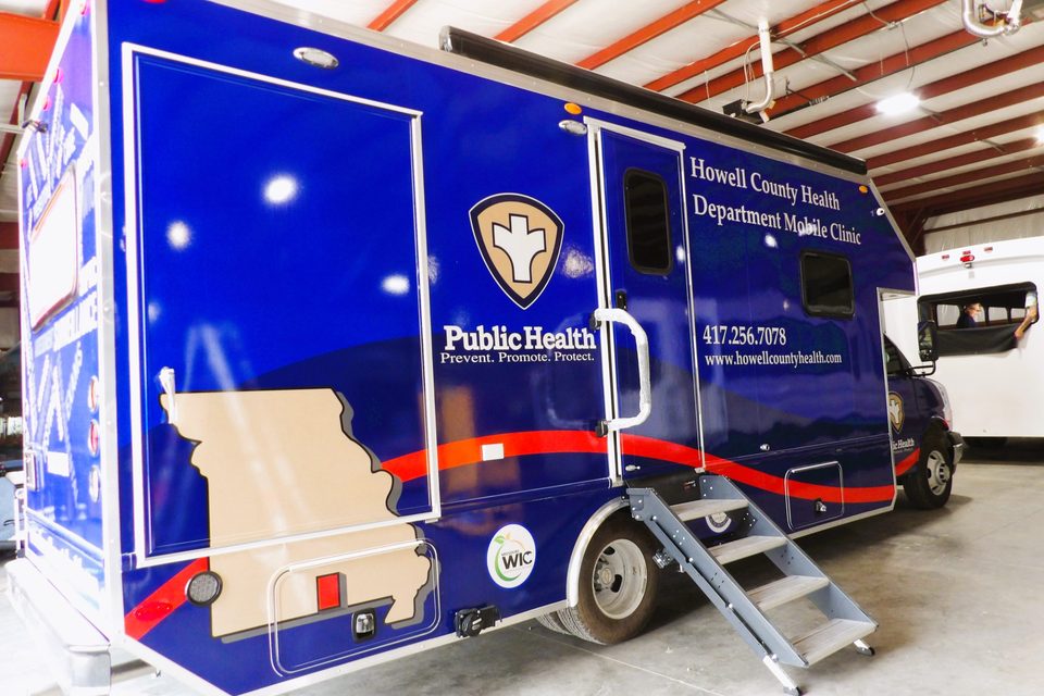 Mobile public-health clinic on a Chevrolet 4500 cutaway, curbside door and entry step down