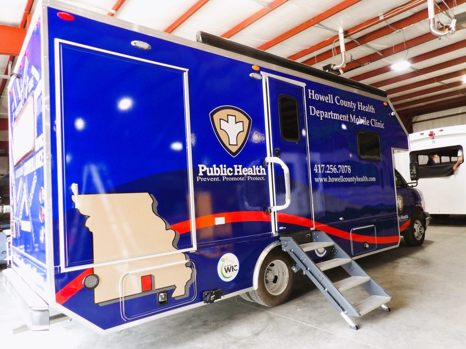 Mobile public-health clinic on a Chevrolet 4500 cutaway, curbside door and entry step down