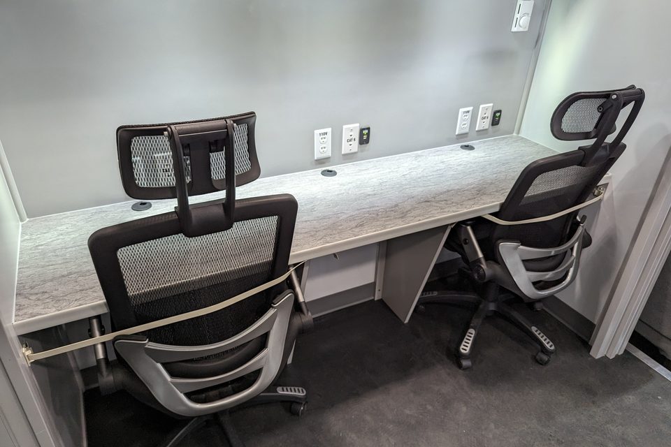 Command unit interior: two workstations with monitors and chairs
