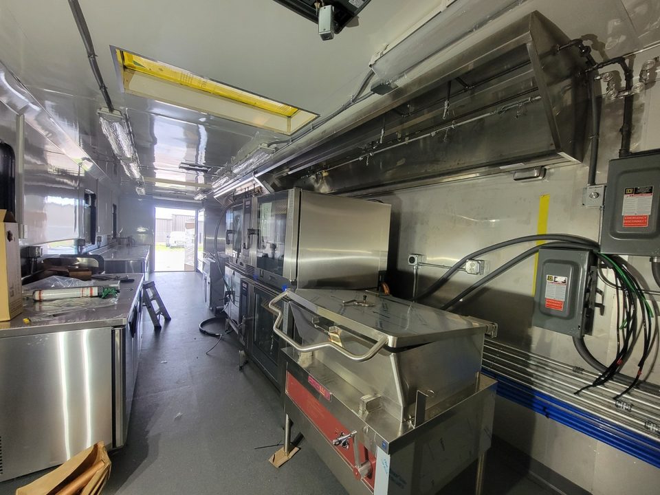 Kitchen container aisle with tilt skillet, stainless walls and skylights