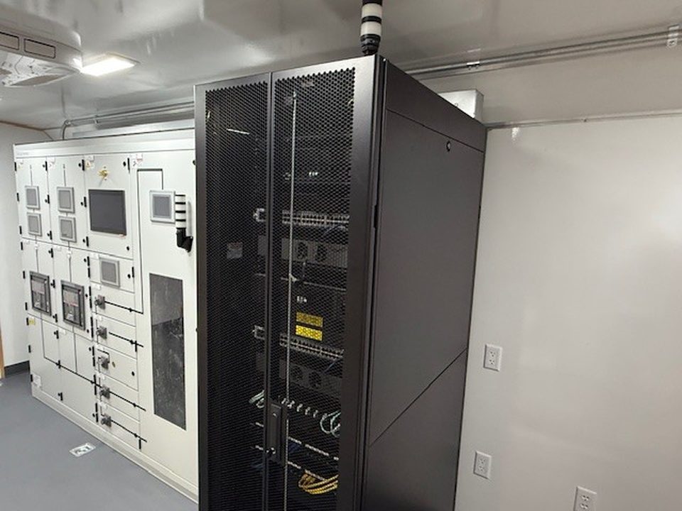Training unit interior: switchgear panels and an open server rack
