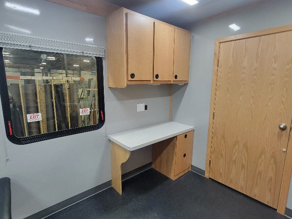 Trailer interior: desk, overhead cabinets and door