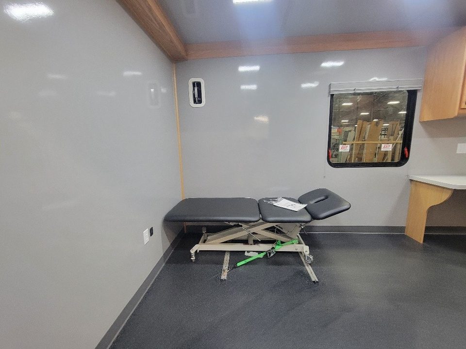 Exam room inside the trailer with a treatment table and window