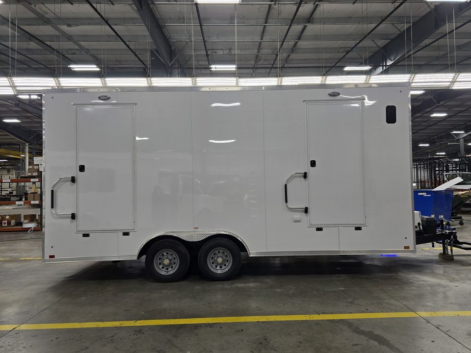White bumper-pull medical trailer, side with two entry doors, in the HLE plant
