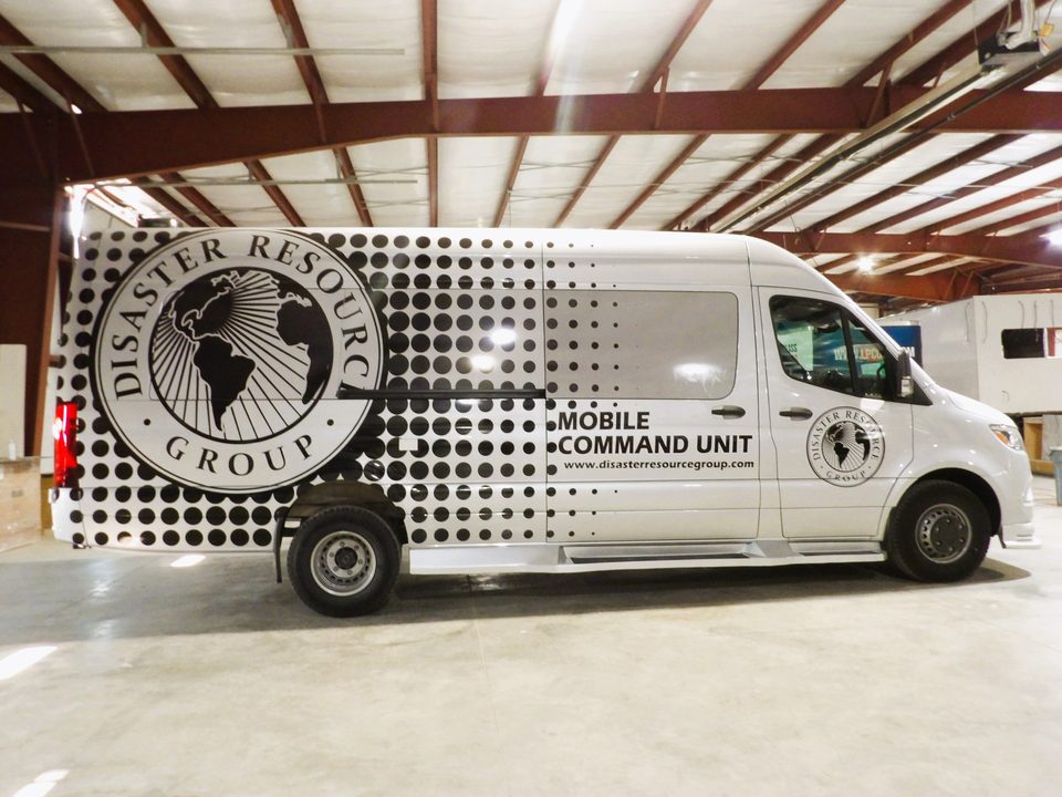 Mercedes-Benz Sprinter mobile command unit, silver with black halftone Disaster Resource Group wrap, side, in the HLE plant