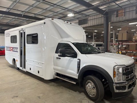 Mobile dental emergency unit on a Ford F-550, white with 1-855-ER-DENTIST lettering, front three-quarter, in the HLE plant