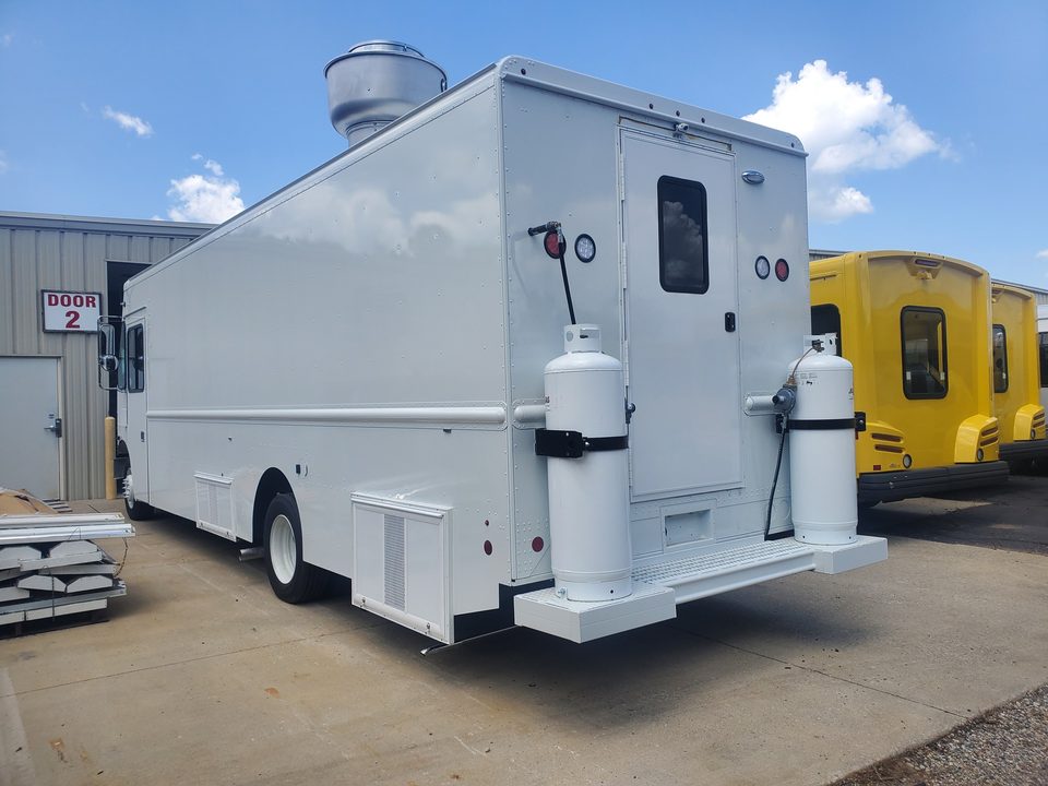 White mobile kitchen on a step van, side