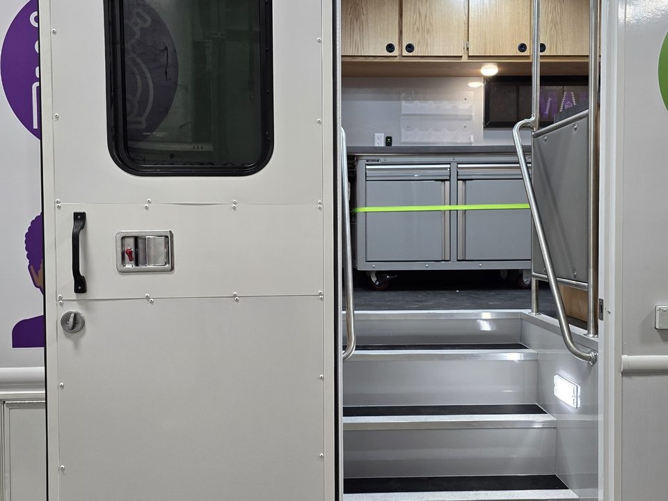 Curbside entry door open showing the stairs and handrails