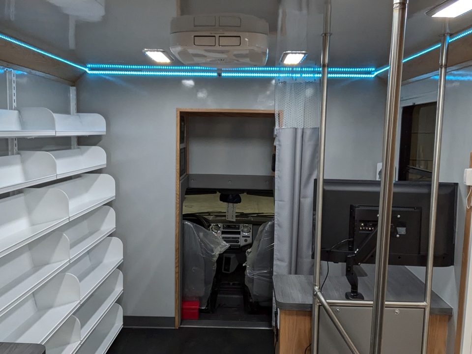 Makerspace interior: shelving, monitor arm and blue LED accent lighting