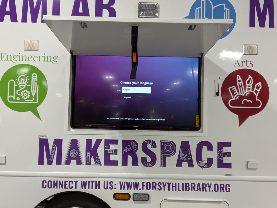 Exterior display screen under an open awning hatch on the makerspace