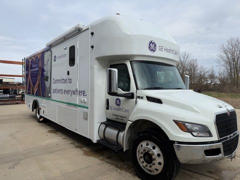 Mobile mammography unit on an International MV, purple GE HealthCare wrap, front three-quarter, outside