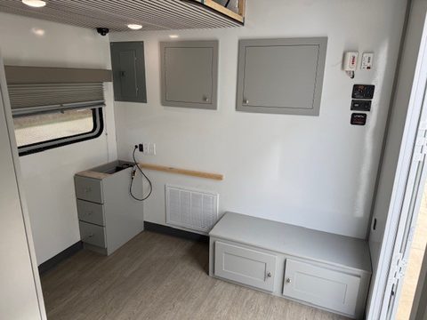 Interior: bench seat, desk and grey cabinets