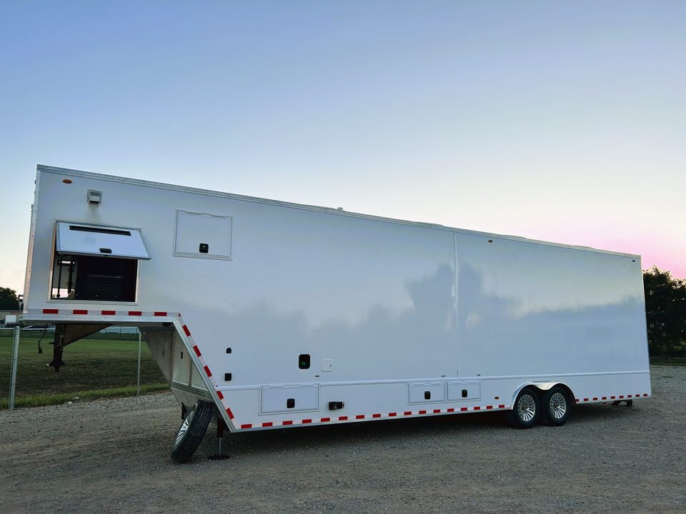 White gooseneck trailer parked outside