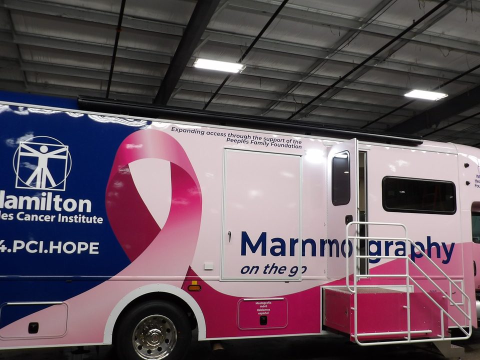 Mammography unit, passenger side, navy and pink wrap reading Mammography on the go