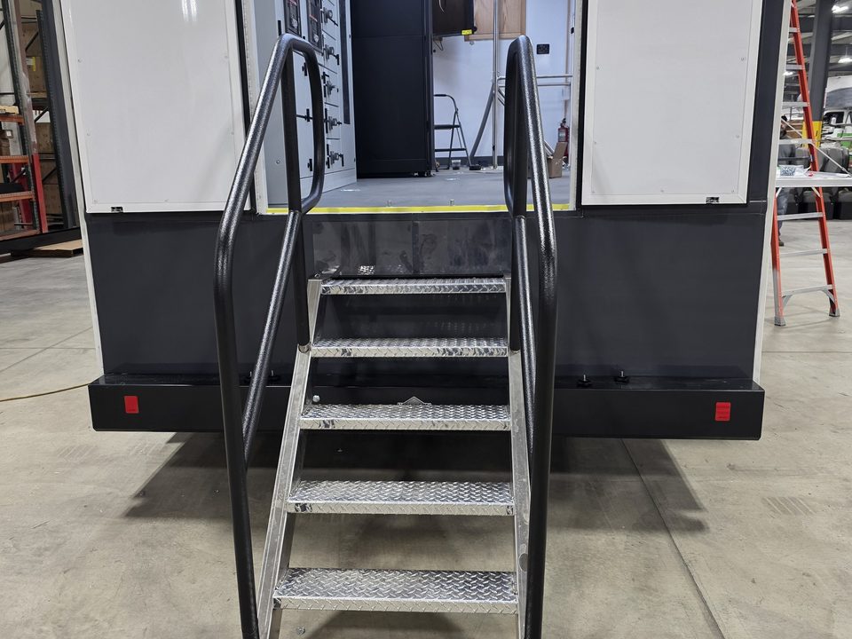 Trailer rear entry with aluminum stairs and handrails, doors open