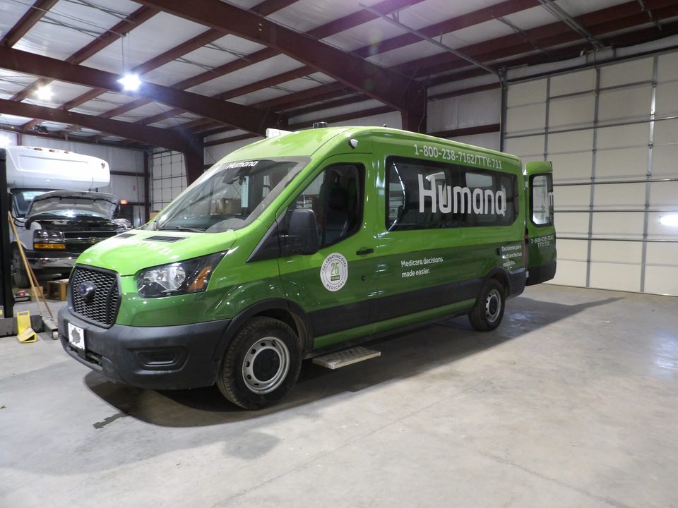 Green Humana outreach van on a Ford Transit, front three-quarter, in the plant