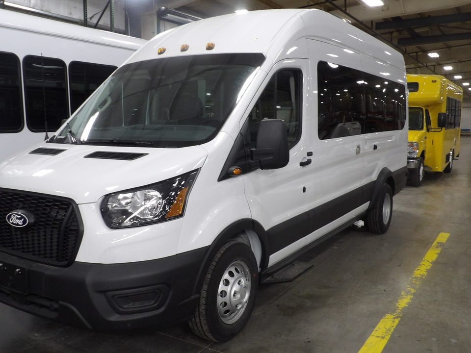 White Ford Transit high-roof van, front three-quarter, in the HLE plant