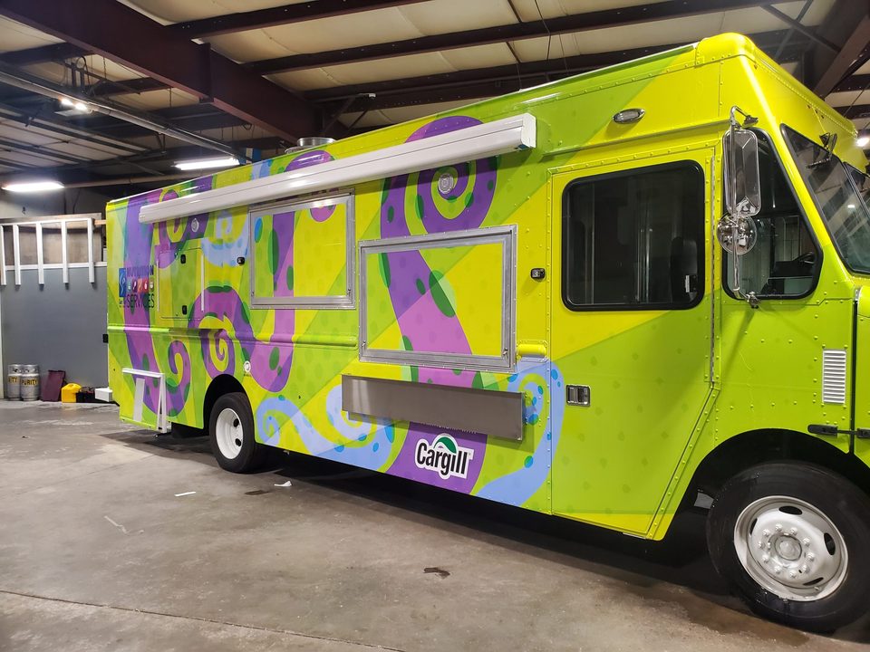 Mobile kitchen on a step van, wrapped, awning out, in the HLE plant