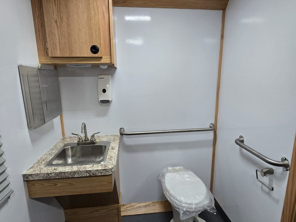 Clinic restroom with sink, toilet and grab bars