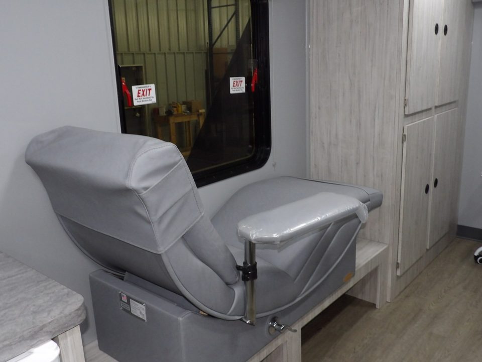 Grey donor recliner beside a window in the bloodmobile