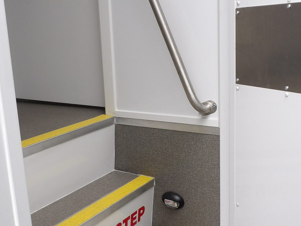 Entry steps with yellow nosing and grab rail inside the outreach unit door