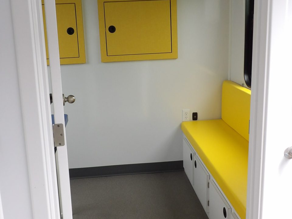 Outreach unit interior: yellow bench seating with storage below