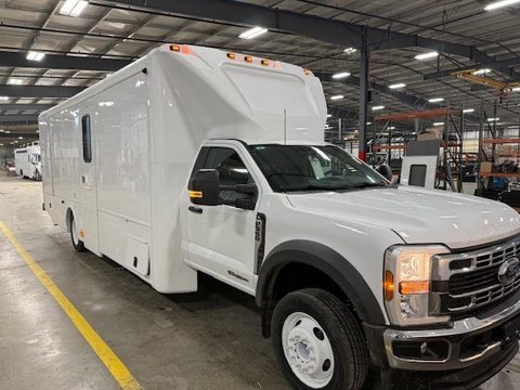 White mobile medical unit on a Ford F-550 with a molded cab cap, front three-quarter, in the HLE plant