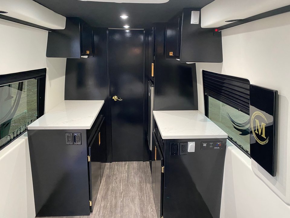 Interior: quartz counters, sink, black cabinetry and a wall-mounted display