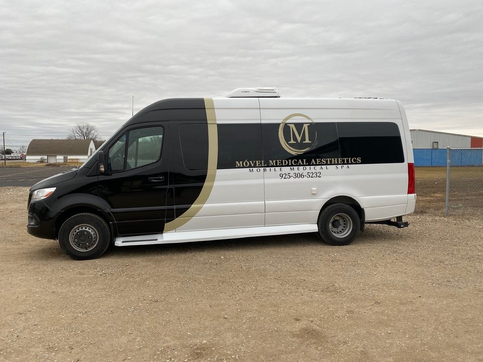 Mercedes-Benz Sprinter mobile medical spa, black and white wrap with gold lettering, side, outside
