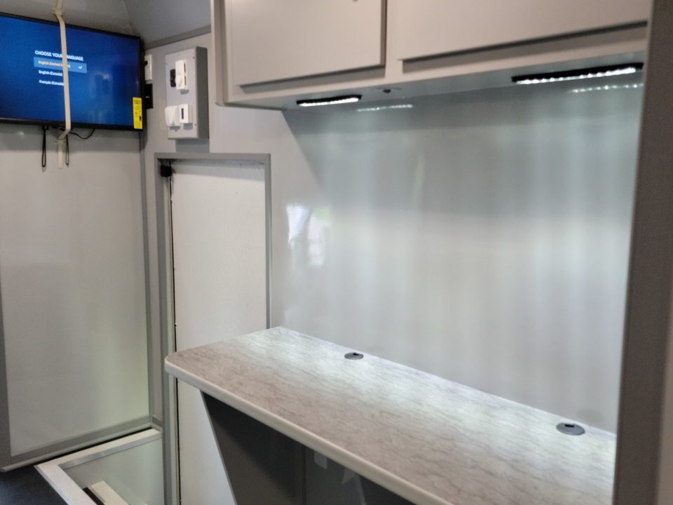 Workstation counter with overhead cabinets and a wall display
