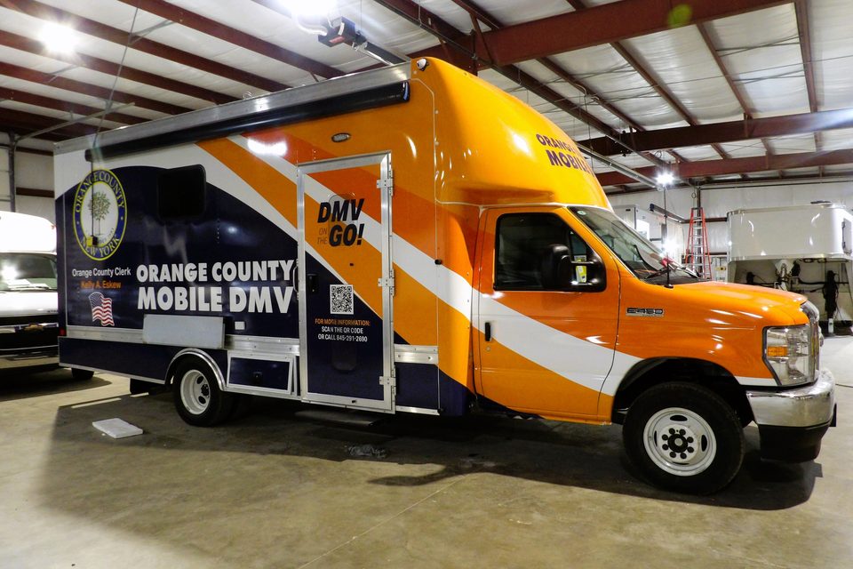 Mobile DMV office on a Ford E-450 cutaway, wrapped orange, front three-quarter