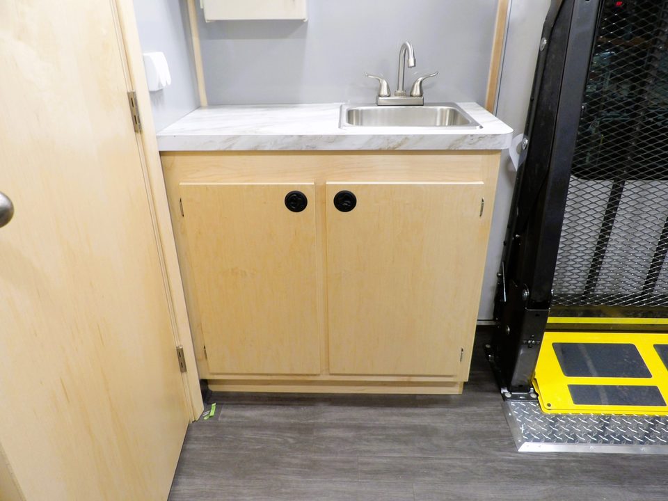 Sink cabinet with the wheelchair lift door beyond