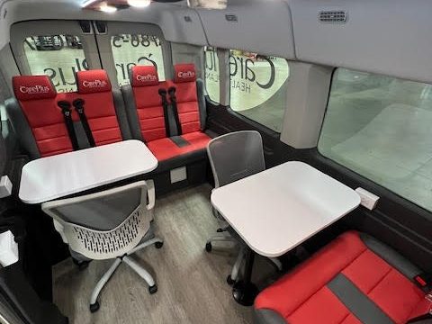 Outreach van interior: table, chairs, bench seating