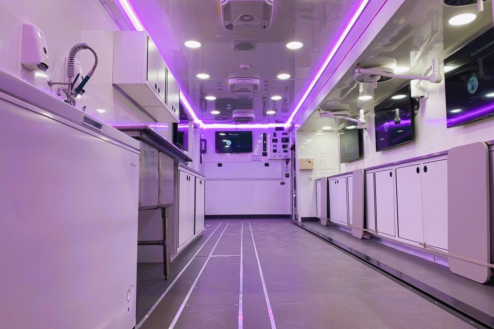 Lab trailer interior with stainless counters under purple LED cove lighting