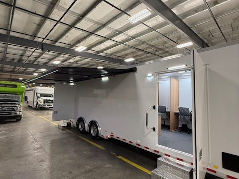 Voting trailer with side double doors open showing the booths