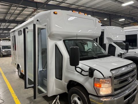 White prisoner transport on a Ford E-450 cutaway, front three-quarter, entry door open, in the HLE plant