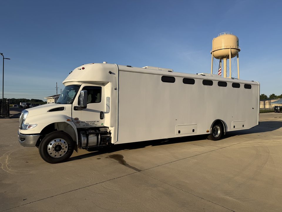 Prisoner transport vehicle outside the HLE plant with the water tower behind