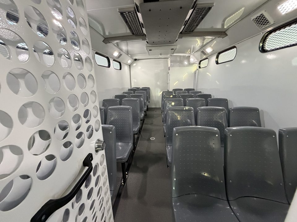 Prisoner transport interior: molded seats, perforated steel partitions, secure restroom at the rear