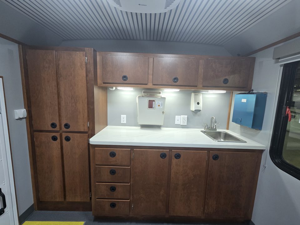 Counter with sink, wood cabinets and dispensers inside the health unit